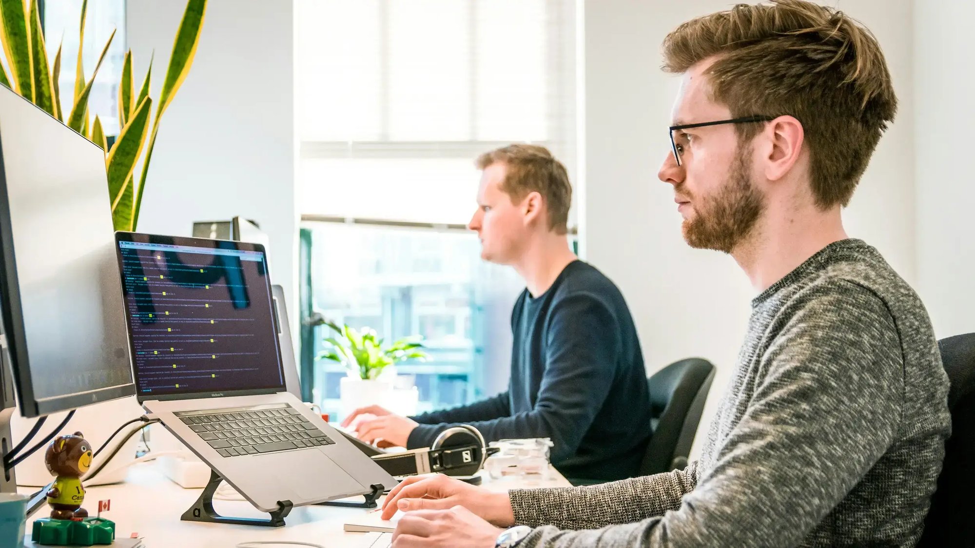 Two of Esatto's developers working at their desks.