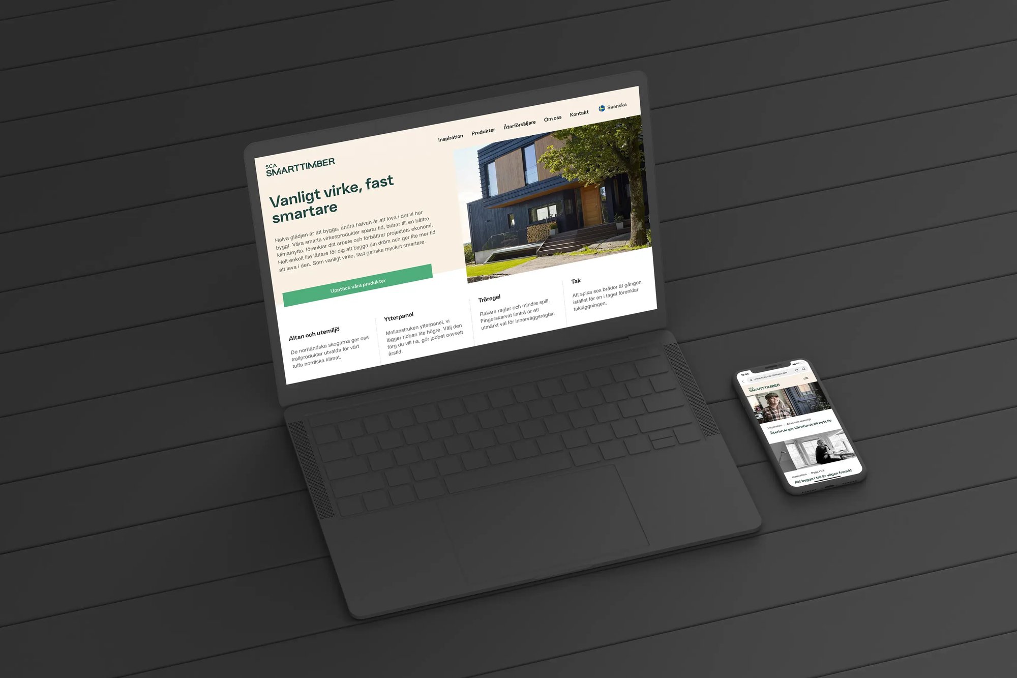 En uppslagen laptop och en mobil på ett bord, båda med SCA SmartTimbers webbplats på skärmen.