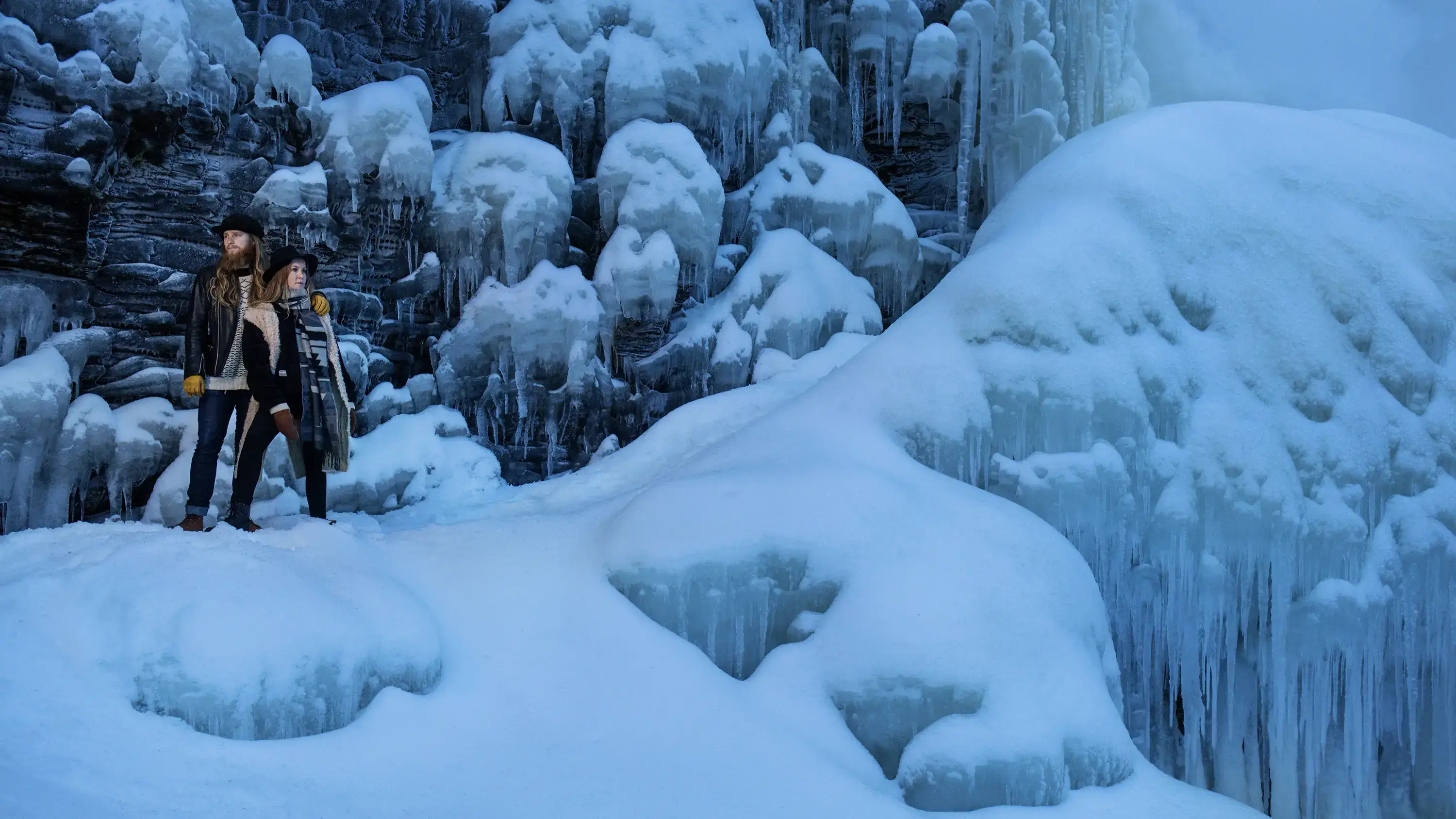 man and woman standing in a landscape made of snow and ice