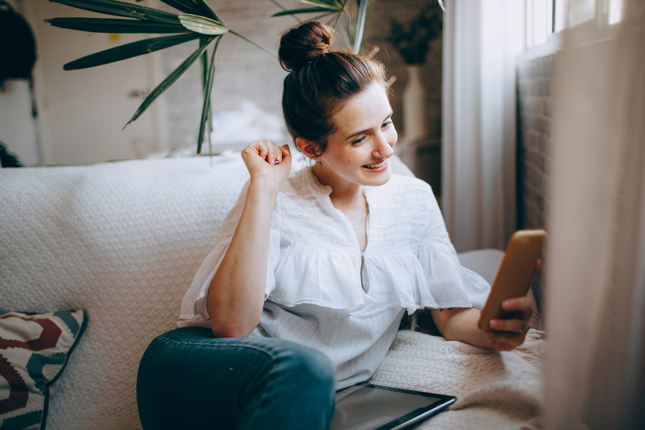 Woman on a couch using her phone.